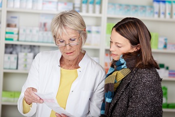 Pharmacy staff member consulting with customer