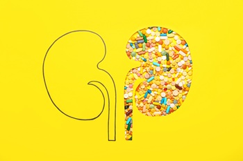Paper kidneys with pills on yellow background