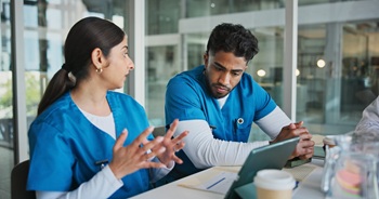 Hospital, tablet and nurses in meeting with paperwork for patient results, medical report and planning. Healthcare, team and man and woman on tech for consulting, discussion and surgery schedule