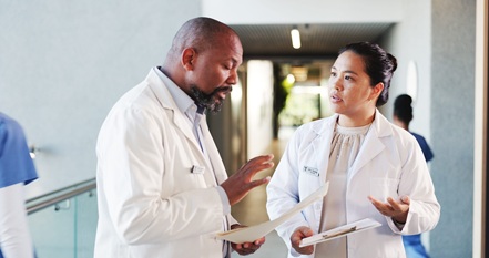 Doctors, conversation and people in hospital, documents and cooperation with feedback. Medical service, man and woman with healthcare, paperwork and support with clinic schedule, talking and advice.